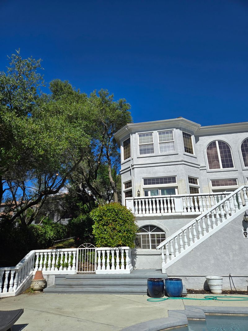 After tree work: reduced, opened-up tree canopy behind the same Los Gatos home